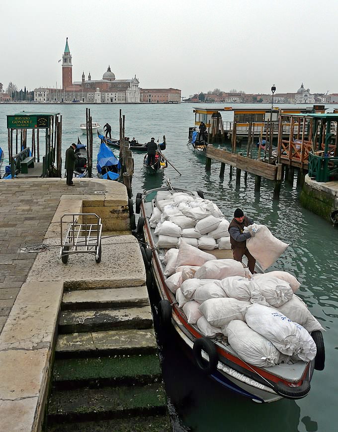 rio del Vin, devant l'hôtel Danieli, ce vénitien empilait sur sa barge les sacs de linge à nettoyer