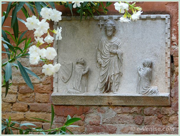 haut relief corte Sant Andrea à Venise et datant de 1356 où l'on peut voir Saint André entouré, de gauche à droite, du frère et prieur Marco Minotto, représenté avec le blason aux armes de la famille Minotto, et de l'autre côté, Ludovico da Ponte 