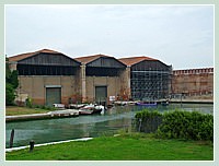 Les 3 hangars (1539) qui servaient de cales pour les galéasses. Le hangar de gauche abrite aujourd'hui les bateaux de parade des cortèges historiques de Venise, dont la Sérénissima.