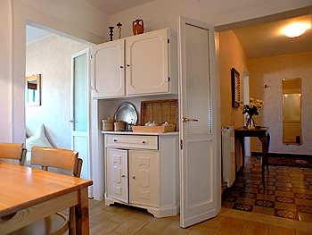 A droite du vaisselier l'entrée et à gauche l'accès au salon